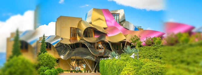 Trip Portugal Reisetipps - Marqués de Riscal Design Hotel, Bilbao, Elciego, Spanien. Fantastisch galaktisch, unverkennbar ein Werk von Frank O. Gehry. Inmitten idyllischer Weinberge in der Rioja Region des Baskenlandes, bezaubert das schimmernde Bauobjekt mit einer Struktur bunter, edel glänzender verflochtener Metallbänder. Glanz im Baskenland - Es muss etwas ganz Besonderes sein. Emotional, zukunftsweisend, einzigartig. Denn in dieser Region, etwa 133 km südlich von Bilbao, sind Weingüter normalerweise nicht für die Öffentlichkeit zugänglich.